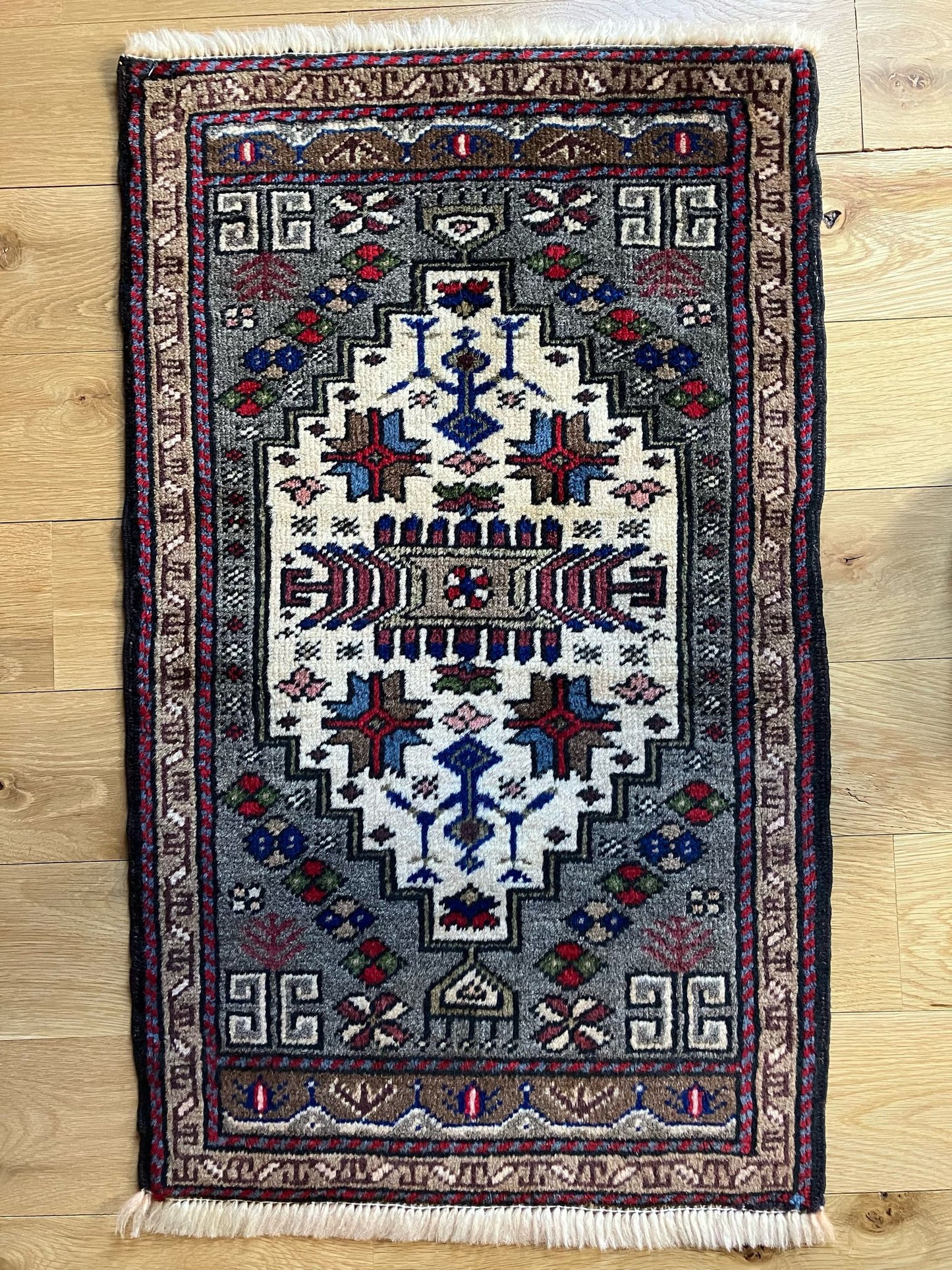 Handmade vintage Turkish entryway rug made of 100% wool, featuring blue, red, and beige colors.