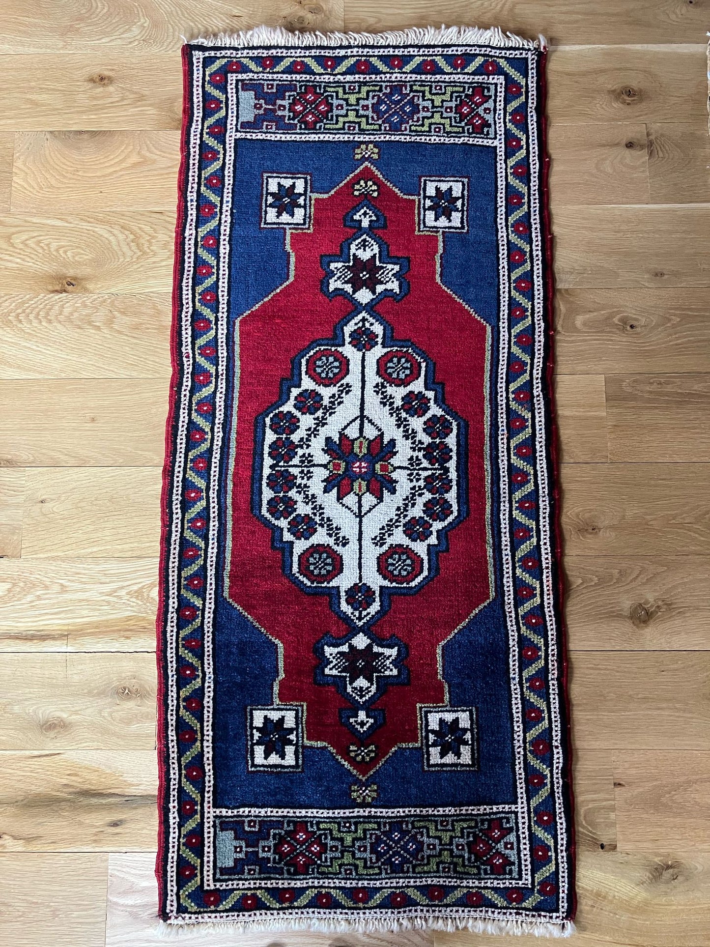 Handmade vintage Turkish entryway rug made of a cotton foundation and a wool pile, featuring red and blue colors.