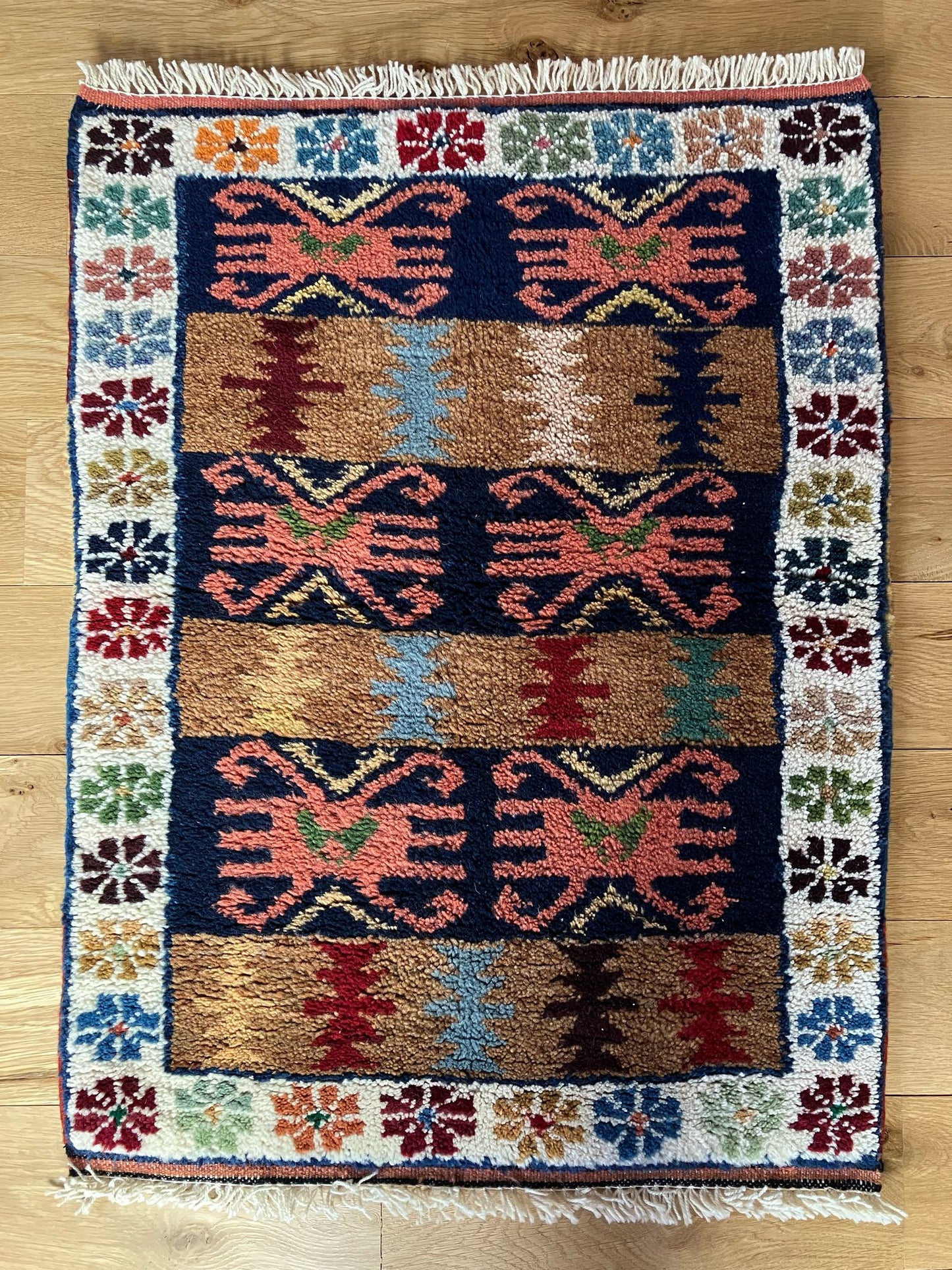 Handmade vintage Turkish entryway rug made of a cotton foundation and a wool pile, featuring red, blue, brown and beige colors.