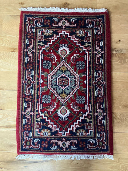 Handmade vintage Persian entryway rug made of a cotton foundation and a wool pile, featuring  red and blue colors.