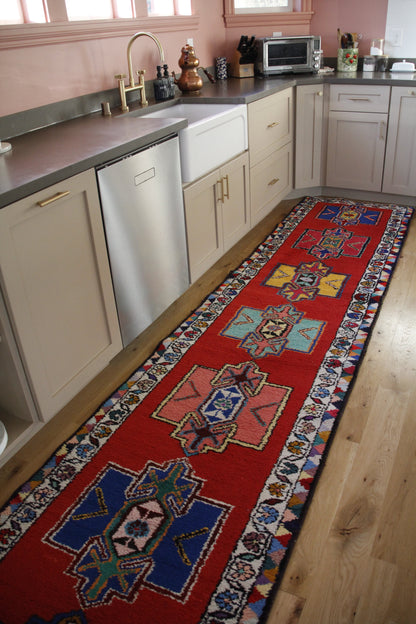 Handmade vintage Persian runner made of 100% cotton, featuring vibrant red and geometric patterns.
