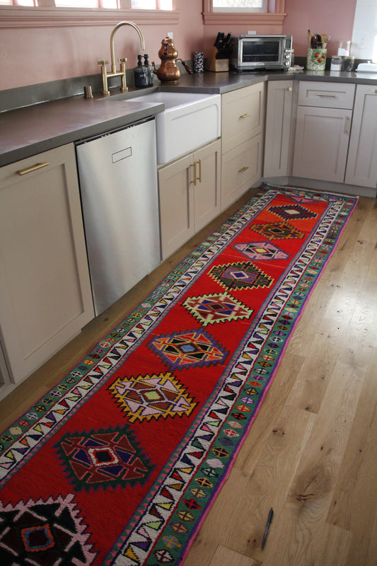 Handmade vintage Persian runner made of 100% cotton, featuring vibrant red, pink and green colors.