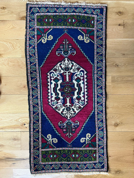 Handmade vintage Turkish entryway rug made of 100% wool, featuring red, blue, and green colors.   