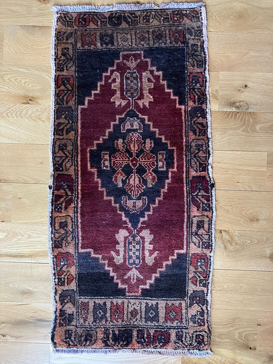 Handmade vintage Turkish entryway rug made of a cotton foundation and a wool pile, featuring  red and black colors.