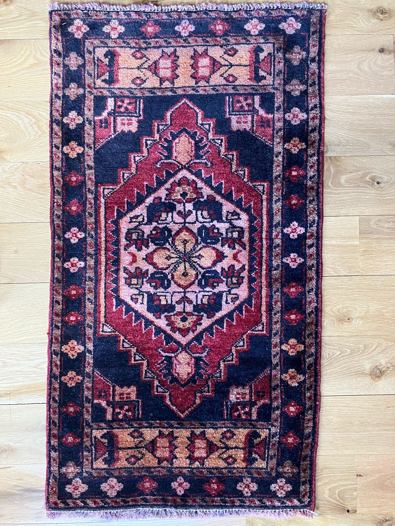 Handmade vintage Turkish entryway rug made of 100% wool, featuring red and black colors.   