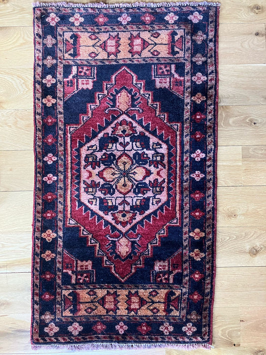 Handmade vintage Turkish entryway rug made of 100% wool, featuring red and black colors.   