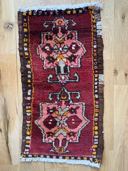 Handmade vintage Turkish entryway rug made of a cotton foundation and a wool pile, featuring  a red background.