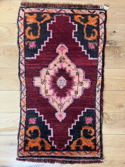 Handmade vintage Turkish entryway rug made of a cotton foundation and a wool pile, featuring  red, black, and orange colors.