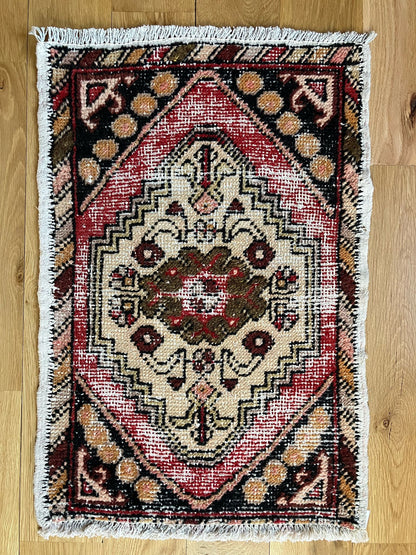 Handmade vintage Turkish entryway rug made of a cotton foundation and a wool pile, featuring  red, beige, and black colors.