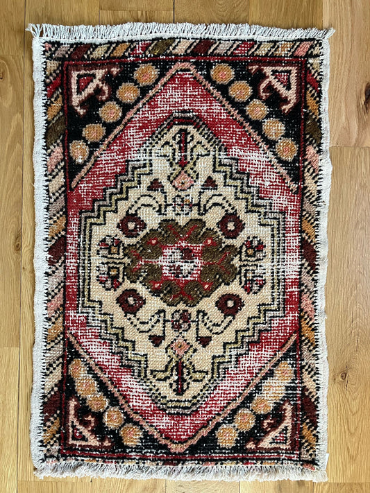 Handmade vintage Turkish entryway rug made of a cotton foundation and a wool pile, featuring  red, beige, and black colors.