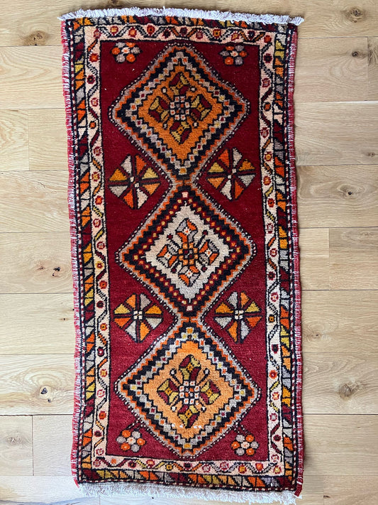 Handmade vintage Turkish entryway rug made of a cotton foundation and a wool pile, featuring  red and orange colors.