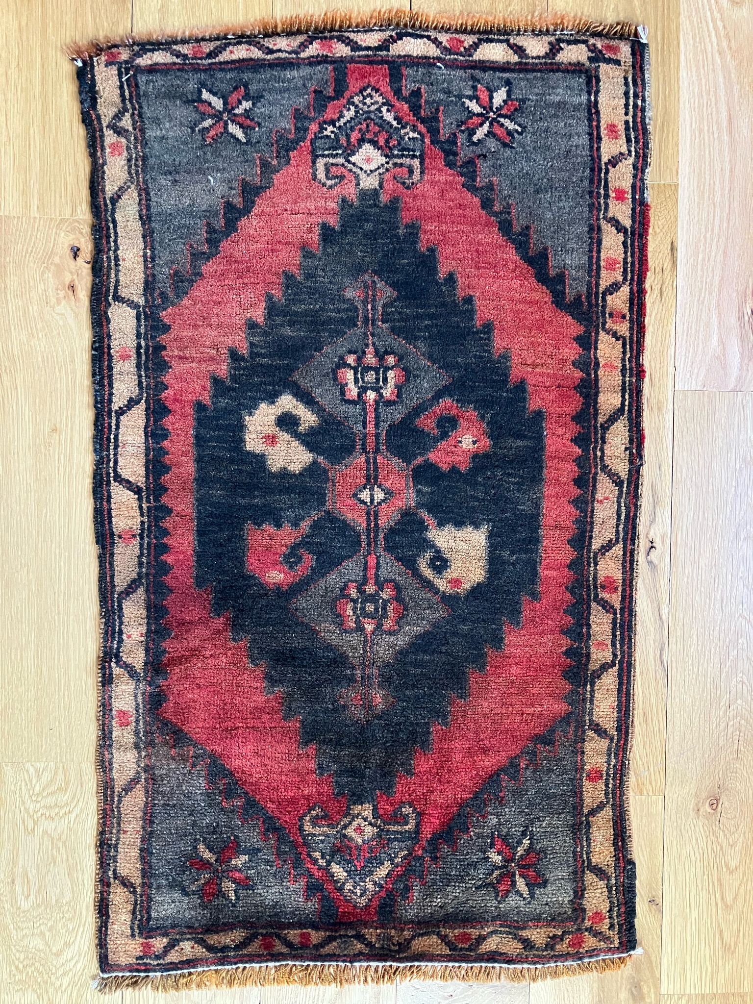 Handmade vintage Turkish entryway rug made of 100% wool, featuring red and black colors.