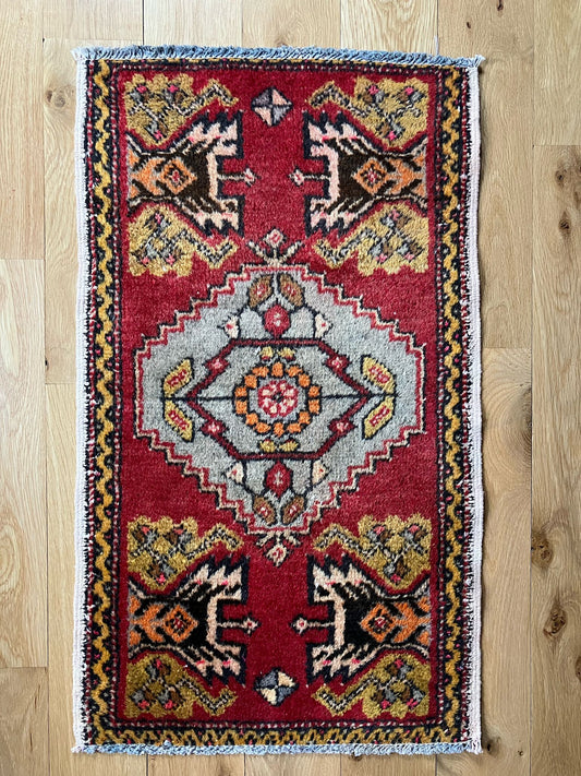 Handmade vintage Turkish entryway rug made of a cotton foundation and a wool pile, featuring red, white and black colors.