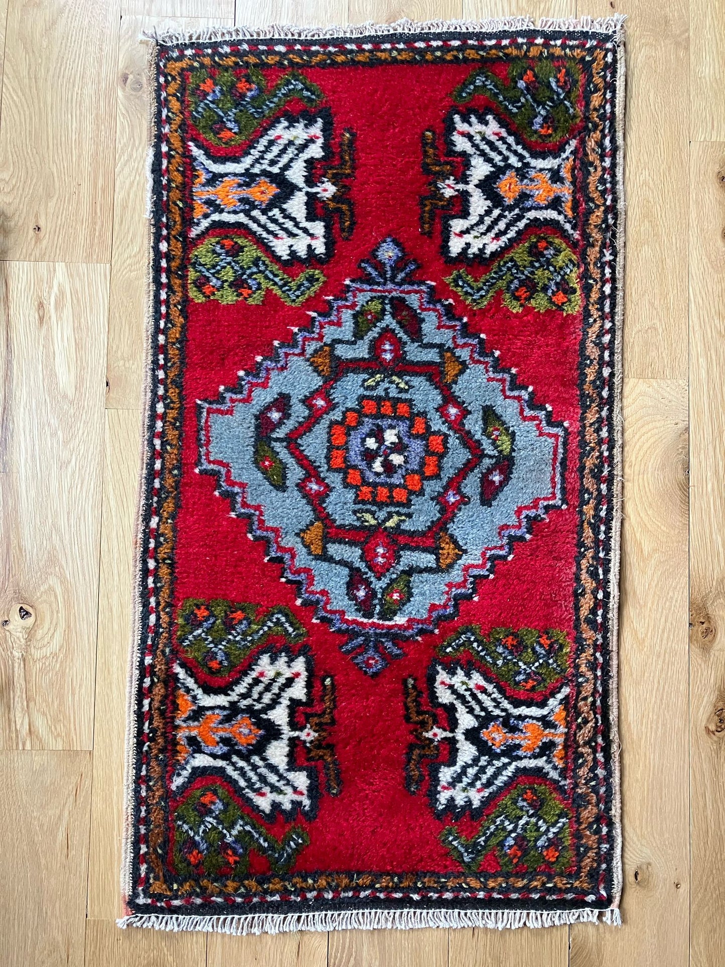 Handmade vintage Turkish entryway rug made of a cotton foundation and a wool pile, featuring red, white and black colors.