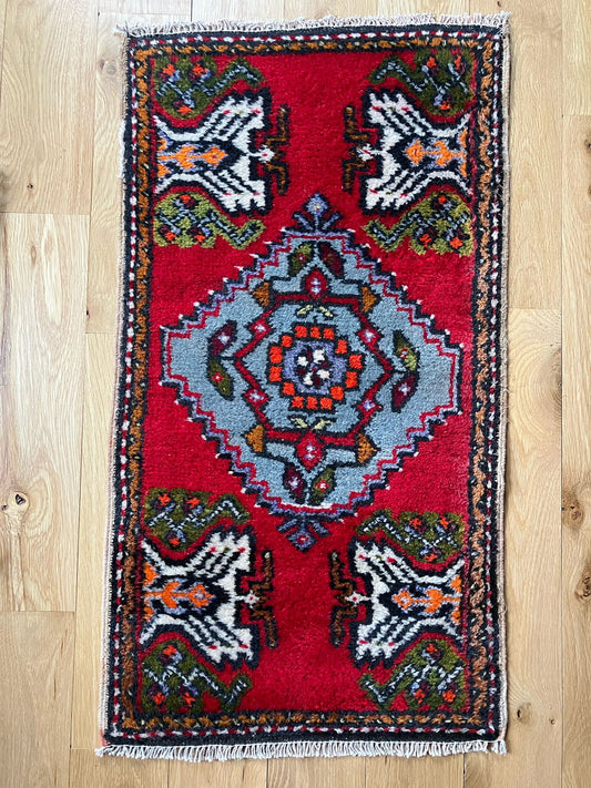 Handmade vintage Turkish entryway rug made of a cotton foundation and a wool pile, featuring red, white and black colors.