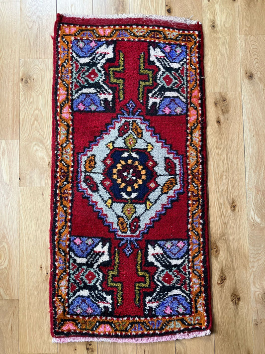 Handmade vintage Turkish entryway rug made of a cotton foundation and a wool pile, featuring red, white and black colors.