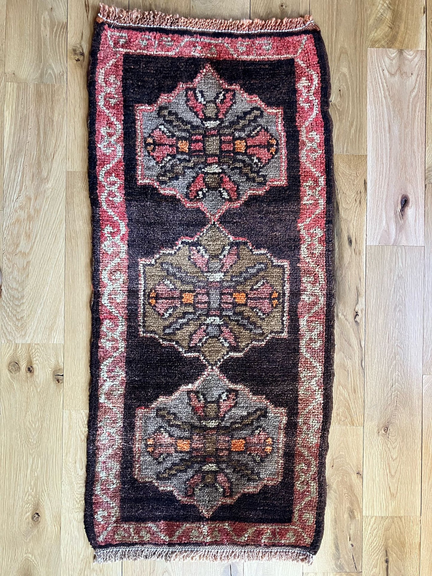 Handmade vintage Turkish entryway rug made of 100% wool, featuring red and black colors.