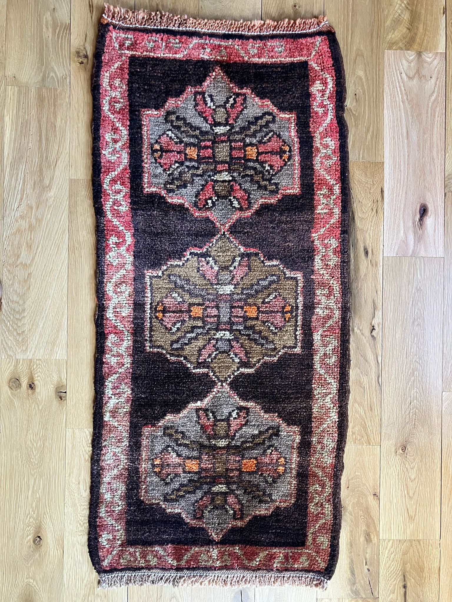 Handmade vintage Turkish entryway rug made of 100% wool, featuring red and black colors.