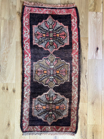 Handmade vintage Turkish entryway rug made of 100% wool, featuring red and black colors.