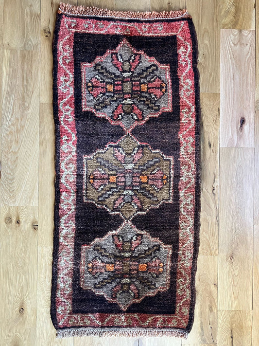 Handmade vintage Turkish entryway rug made of 100% wool, featuring red and black colors.