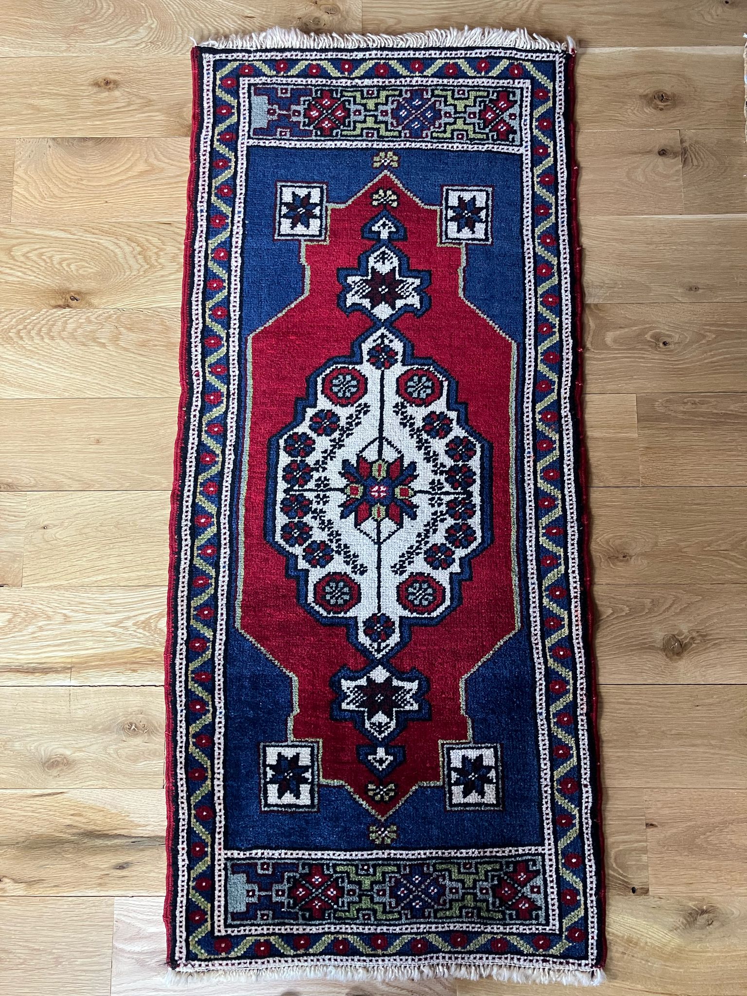 Handmade vintage Turkish entryway rug made of a cotton foundation and a wool pile, featuring  red and blue colors.