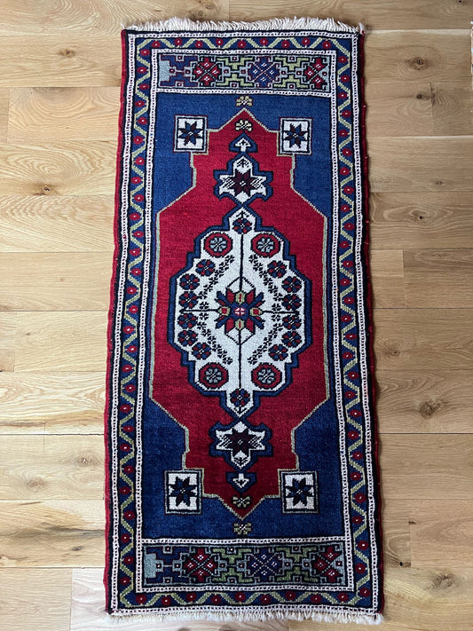 Handmade vintage Turkish entryway rug made of a cotton foundation and a wool pile, featuring  red and blue colors.