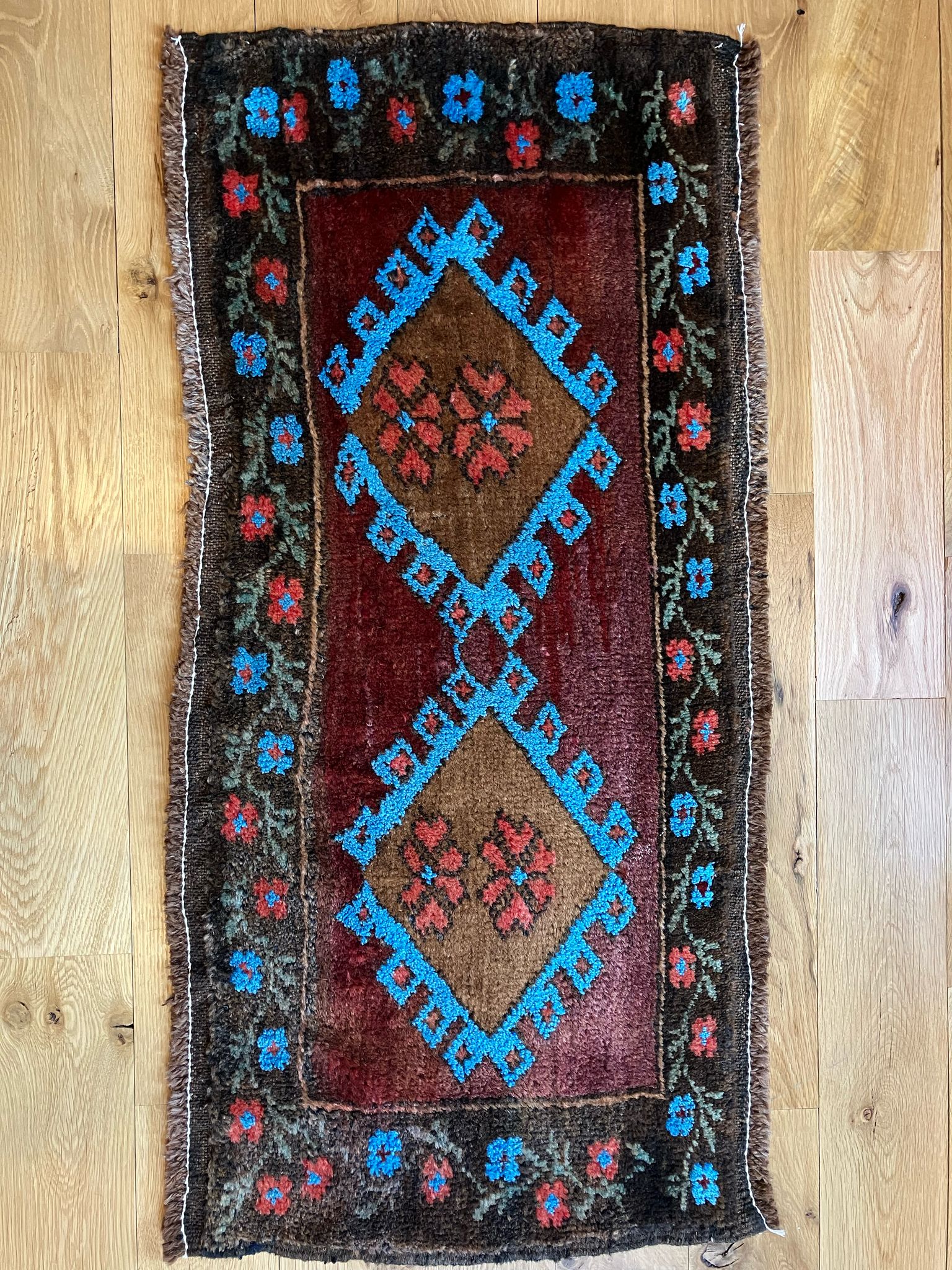 Handmade vintage Turkish entryway rug made of 100% wool, featuring red, blue, and brown colors.                                                           