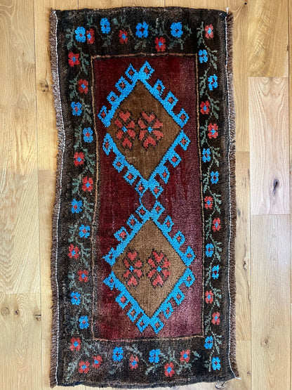 Handmade vintage Turkish entryway rug made of 100% wool, featuring red, blue, and brown colors.                                                           