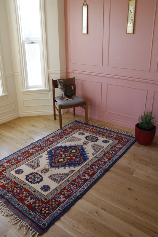 Handmade vintage Turkish medium rug made of 100% wool, featuring red and blue colors.    