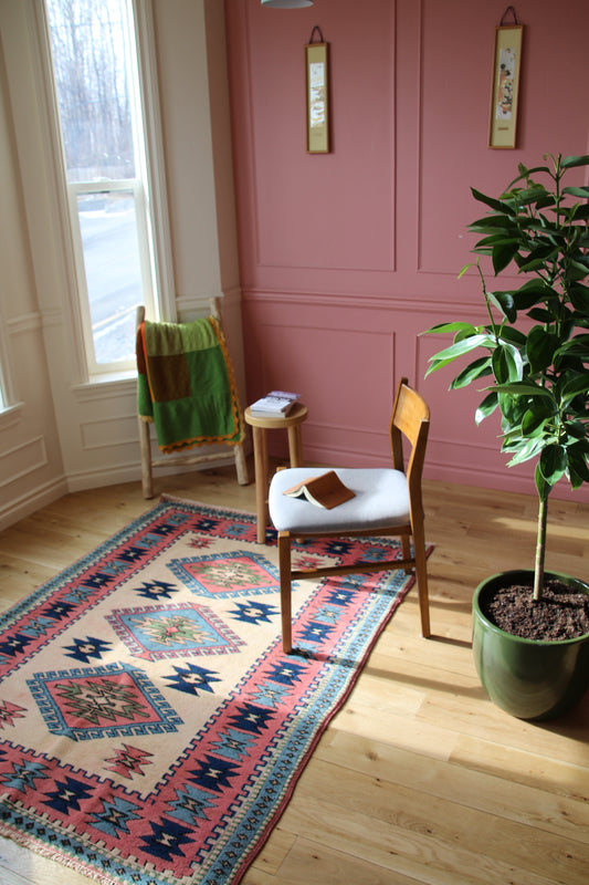 Handmade vintage Turkish medium rug made of 100% wool, featuring pink, blue, and beige colors.    