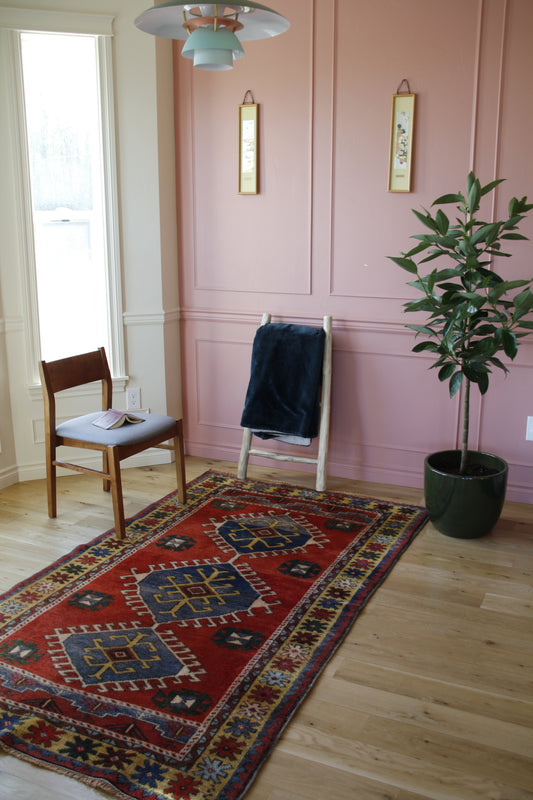 Handmade vintage Turkish medium rug made of 100% wool, featuring red and blue colors. 