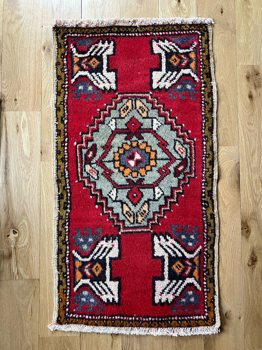Handmade vintage Turkish entryway rug made of a cotton foundation and a wool pile, featuring red, white and black colors.
