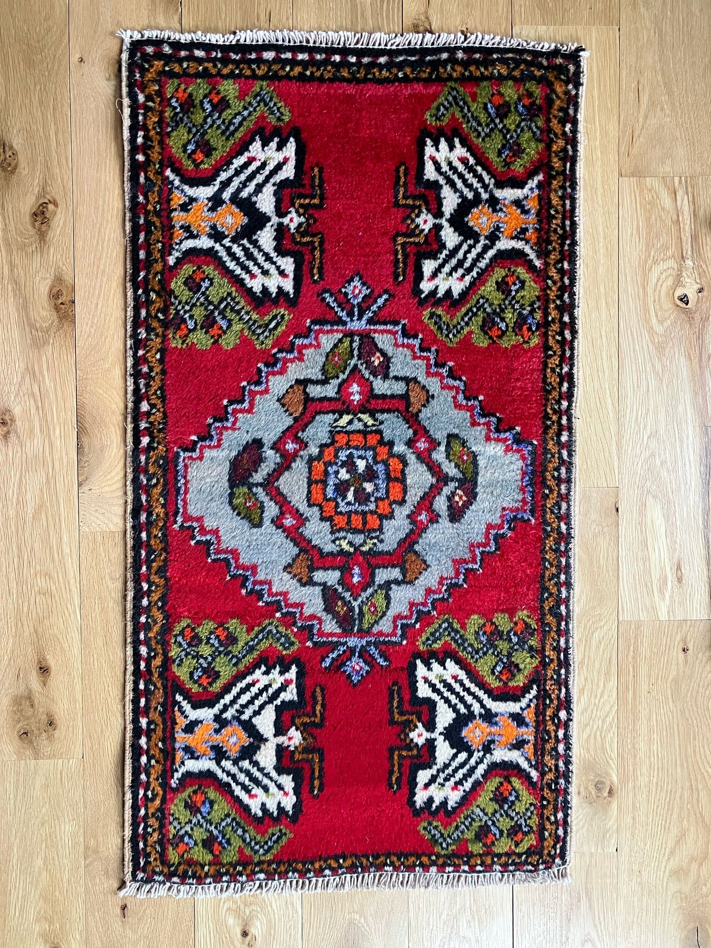 Handmade vintage Turkish entryway rug made of a cotton foundation and a wool pile, featuring red, white and black colors.