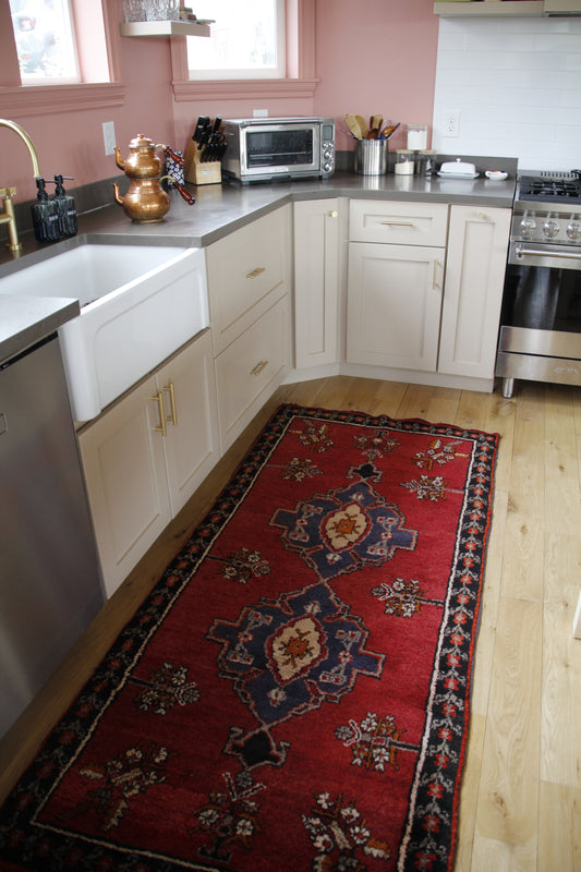 Handmade vintage Turkish runner made of 100% wool, featuring red, blue, and black colors.    