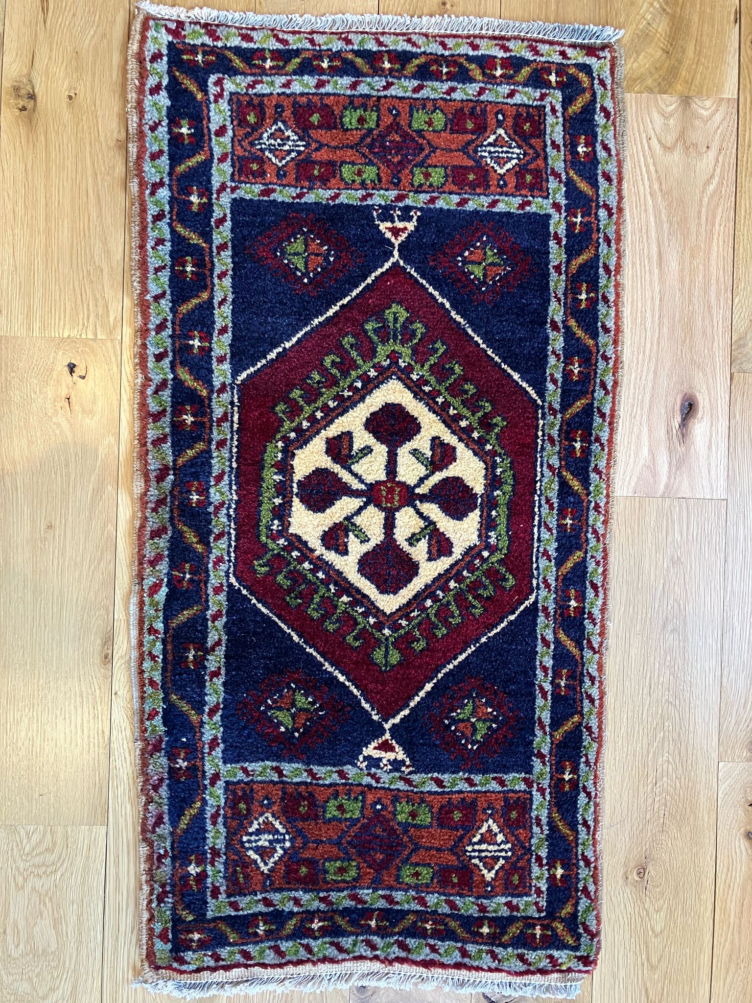 Handmade vintage Turkish entryway rug made of a cotton foundation and a wool pile, featuring  red, blue, and beige colors.