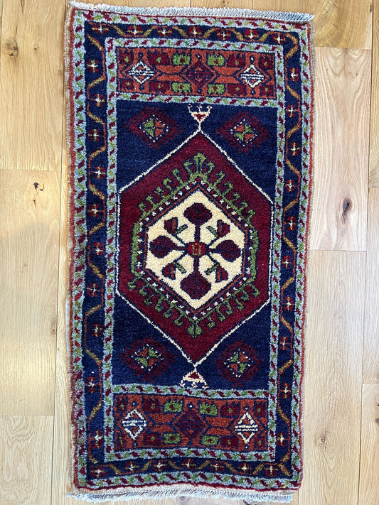 Handmade vintage Turkish entryway rug made of a cotton foundation and a wool pile, featuring  red, blue, and beige colors.